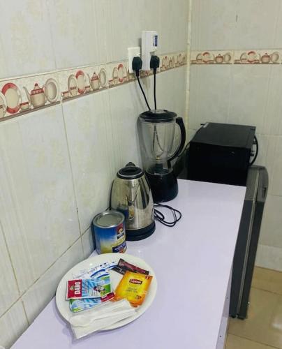 a counter top with a blender and a plate of food at Beevock Apartment in Gwarinpa