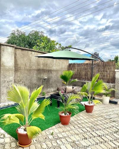 a patio with potted plants and an umbrella at Beevock Apartment in Gwarinpa