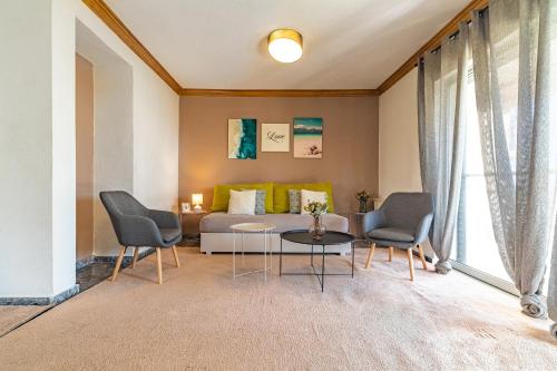 米洛伊的住宿－Almyros Sea Front Villa，客厅配有沙发、两把椅子和一张桌子