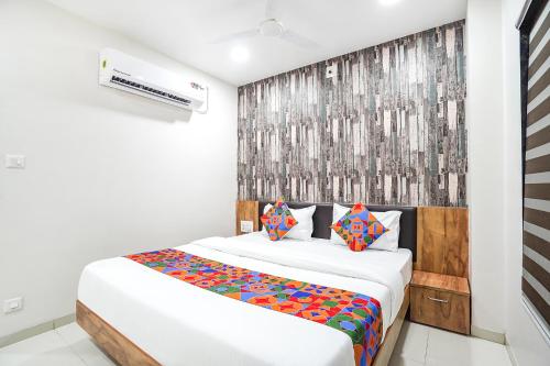 ein Schlafzimmer mit einem großen weißen Bett mit bunten Kissen in der Unterkunft FabHotel Prime Palace View in Vadodara