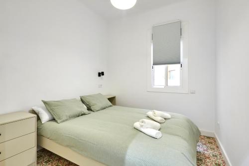 a bedroom with a bed with white towels on it at Comfortable apartment next to Apolo theater in Barcelona