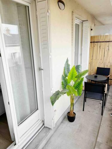 een veranda met een potplant en een tafel bij Paris JO / Proche Aéroport CDG / Centre Chantilly in Chantilly