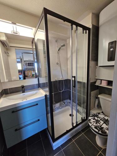 une salle de bain avec une douche, un lavabo et des toilettes dans l'établissement la playa, à Gruissan