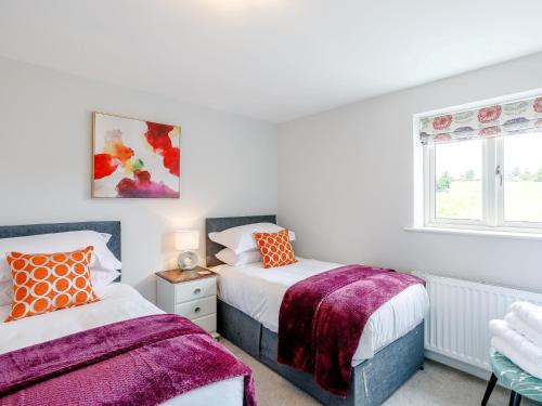 a bedroom with two beds and a window at 5 Bed in Tealby 78678 in Tealby