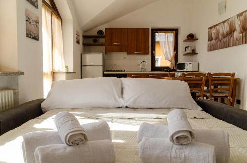 um quarto com uma cama grande e toalhas em Sarre Skyline Apartment - Relax in Valle d'Aosta em Aosta