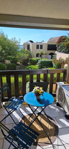 une table bleue et des chaises sur un balcon dans l'établissement la playa, à Gruissan