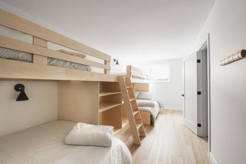 a bedroom with two bunk beds and a staircase at Villas Perspective-Alphonse-Mont-Ste-Anne in Beaupré