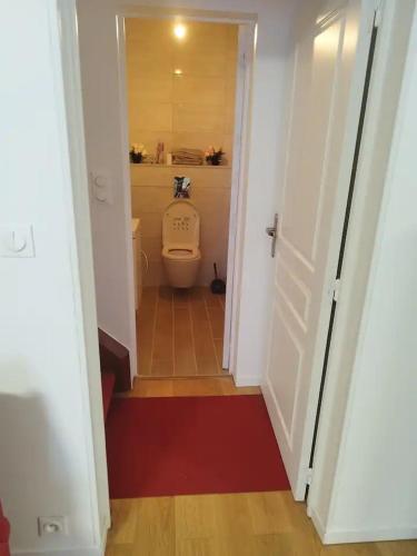 La salle de bains est pourvue de toilettes et d'un tapis rouge. dans l'établissement Belle maison de Campagne Confortable 17 couchages, à La Bazoche-Gouet