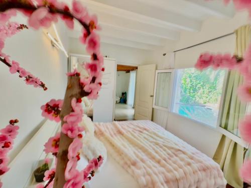 um quarto com uma cama com flores cor-de-rosa em Casa Klod Ibiza em Cidade de Ibiza