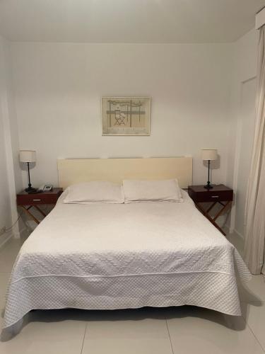 1 dormitorio con 1 cama blanca, 2 mesitas de noche y 2 lámparas en Un bonito lugar en el centro de Buenos Aires en Buenos Aires