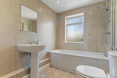 La salle de bains est pourvue d'un lavabo, d'une baignoire et de toilettes. dans l'établissement Mia's House: Park view +Parking, à Nottingham