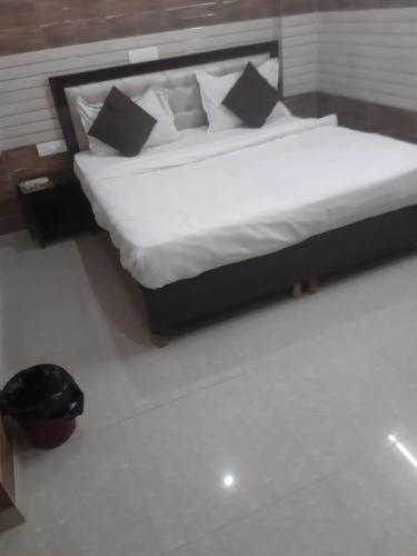 a bed with white sheets and pillows in a room at Diamond Imperial in Noida