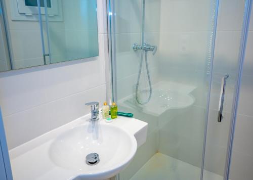 a white bathroom with a sink and a shower at Agi Gloria Rooms in Roses