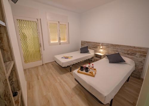 a room with two beds and a table in it at Agi Gloria Rooms in Roses