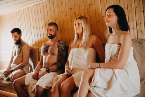 a group of men and women sitting on a couch at Hotel Linea Mare in Pobierowo