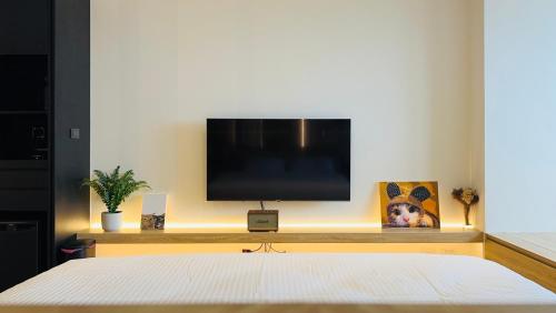 a bedroom with a flat screen tv on a wall at La Vie - Ocean Paradise in Toucheng