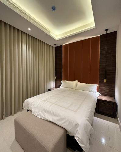 een slaapkamer met een groot wit bed en een bank bij a6 شقه مودرن in Riyad