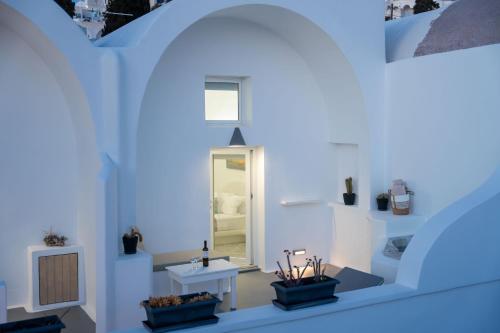 a room with white walls and white tables and a mirror at Casa Evgenia in Pyrgos