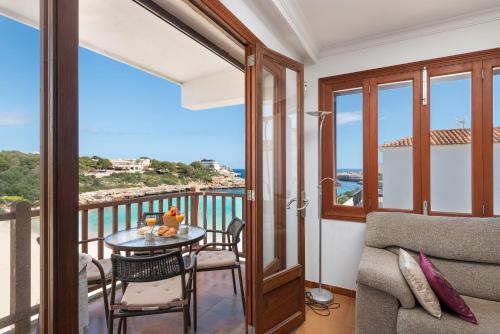 Una habitación con balcón con mesa y sillas. en Apartamento Corb Mari 2 en la playa Cala Marsal!, en Portocolom