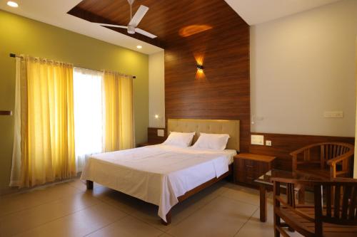 a bedroom with a large bed and a window at Blossom Bed Resort Vagamon by Lexstays in Vagamon