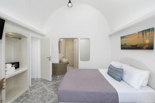 a white room with a bed and a bathroom at Casa Evgenia in Pyrgos
