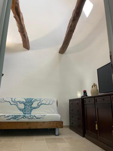 a bedroom with a bed with a tree mural on the wall at Il trullo di nonno Licchio in Alberobello