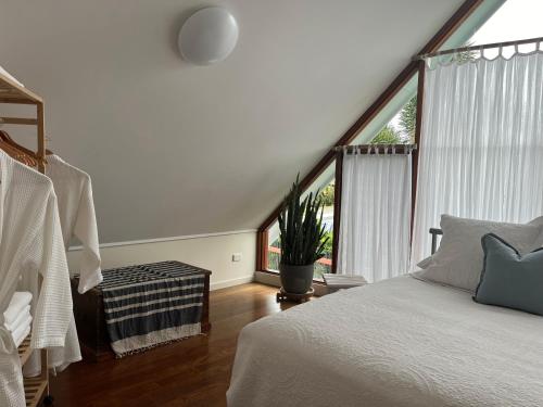 a bedroom with a bed and a large window at The Cowrie Shell, Hydeaway Bay in Hideaway Bay