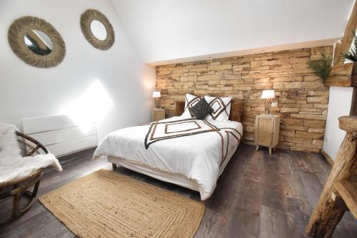 - une chambre avec un lit et un mur en briques dans l'établissement LE RELAIS DES CALECHES - La Jungle Room, 
