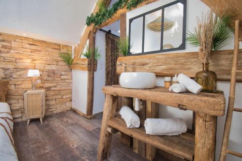 uma casa de banho com paredes de madeira e um lavatório num quarto em LE RELAIS DES CALECHES - La Jungle Room 