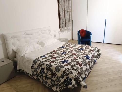 ein Schlafzimmer mit einem Bett mit einer Decke darauf in der Unterkunft Residenza Martignoni Ex Antica Oasi Francescana in Varese