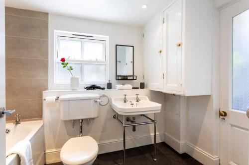 ein Badezimmer mit einem Waschbecken, einem WC und einer Badewanne in der Unterkunft 2-bedroom split-level apartment in Notting Hill in London