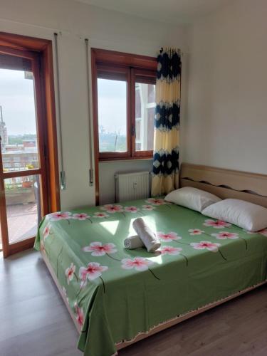a bedroom with a green bed with flowers on it at #Punto FM 1# in Marghera