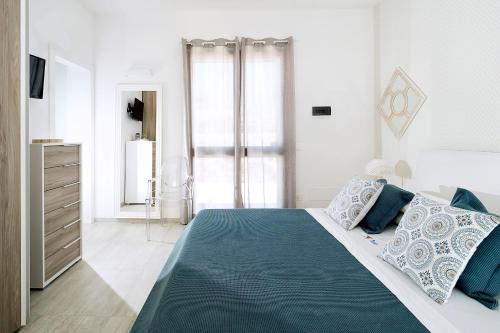 a bedroom with a bed with blue and white pillows at San Lorenzo - Timo in San Lorenzo