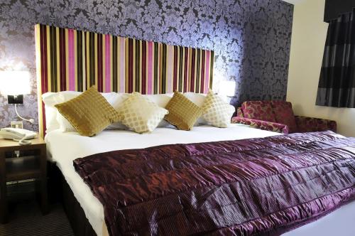 a bedroom with a large bed with a colorful headboard at Hopping Hare in Northampton