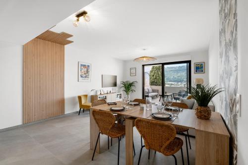 une salle à manger et un salon avec une table et des chaises dans l'établissement La Pinède de La Turbie - Appt vue mer et montagne, à La Turbie