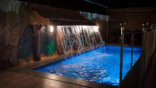 una piscina con cascada en una habitación en Jonirene Seasands, en Alleppey