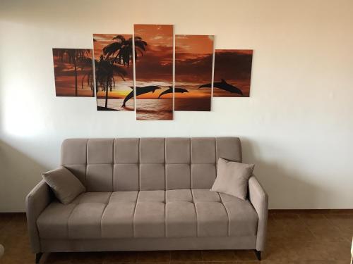 a group of palm trees and a bird on the beach multi panel canvas wall art at Appartamento Dannunzio in Castelnuovo del Garda