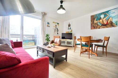 un salon avec un canapé rouge et une table dans l'établissement Corto *2pas de la mer*parking*, à Concarneau