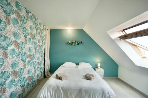 une chambre avec un grand lit avec un mur bleu dans l'établissement Corto *2pas de la mer*parking*, à Concarneau