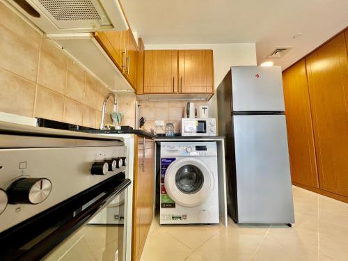 a kitchen with a refrigerator and a washing machine at Cosmos Living Stunning Apt in Lago Vista IMPZ in Dubai