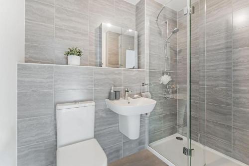 een badkamer met een toilet, een wastafel en een douche bij Scenic getaway, open plan home! 2bed park for free in Eaglesham