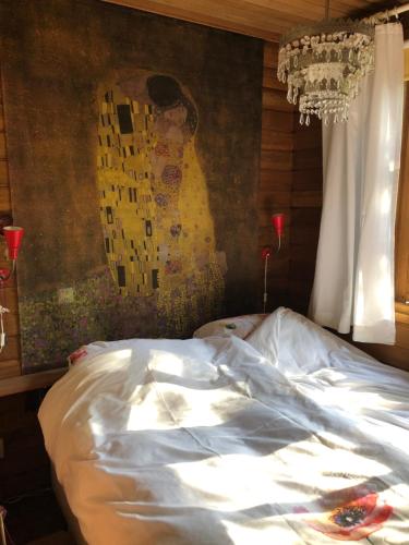 a bed in a bedroom with a painting on the wall at Tempat Hutan in Lochem