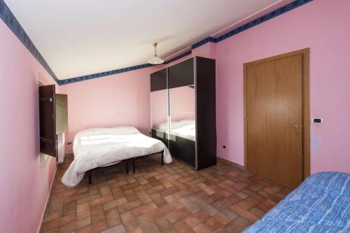 um quarto com 2 camas e um armário com paredes cor-de-rosa em Farmstay Agriturismo La Fonte em Belforte del Chienti