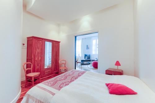 une chambre avec un lit avec un oreiller rouge dessus dans l'établissement Spécial JO - Duplex Lumineux Clichy pour 8, à Clichy
