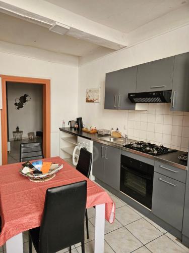 eine Küche mit einem Tisch und einem Herd Top-Backofen in der Unterkunft Bono plages récemment rénové février 2024 in Mèze