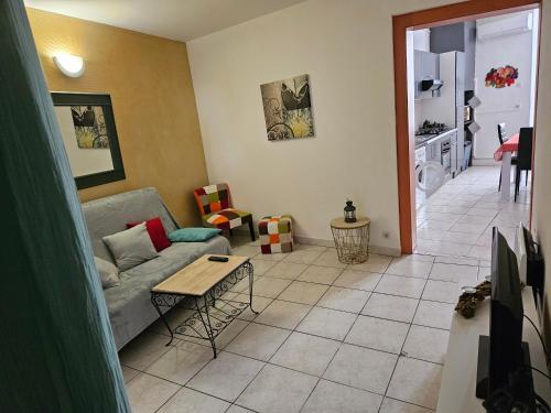 ein Wohnzimmer mit einem Sofa und einem Tisch in der Unterkunft Bono plages récemment rénové février 2024 in Mèze