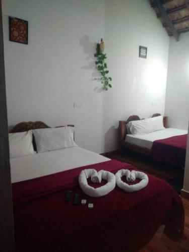 a bedroom with two beds with towels on them at Stillwater Homestay in Chikmagalūr