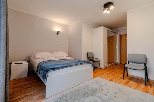 1 dormitorio pequeño con 1 cama y 1 silla en Centrum Wypoczynku i Rekreacji Rysy Krynica Zdrój, en Krynica-Zdrój