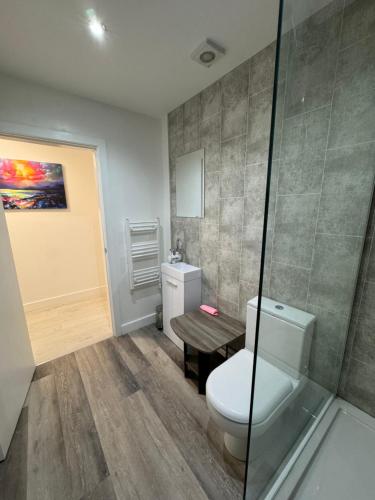 uma casa de banho com um WC e uma mesa de madeira em Urban Stay - Contractor accommodation em Grimsby