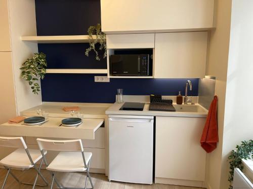 une petite cuisine avec un évier et un micro-ondes dans l'établissement Comme une chambre d’hôtel au cœur de Lyon, à Lyon